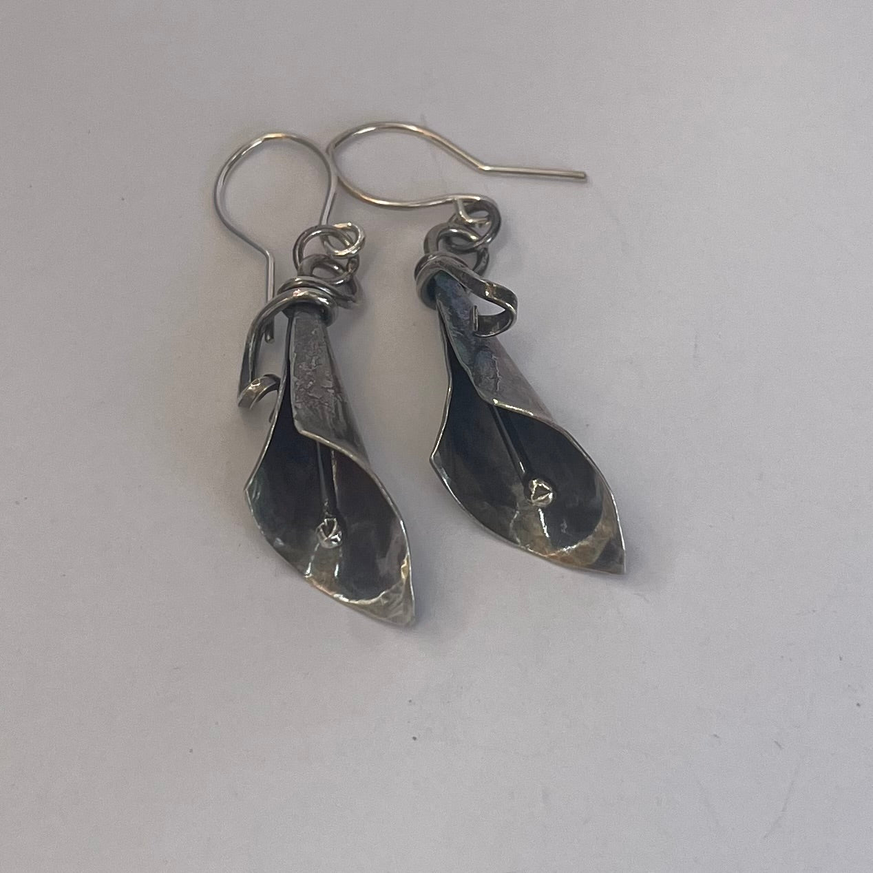 Sterling silver dangle earrings formed into a sweet calla lilly bud, complete with spadix.