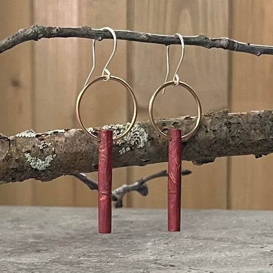 Very cute earring of a brass ring with a dangling roller printed, heat-treated copper cylinder.  Sterling silver earwire.