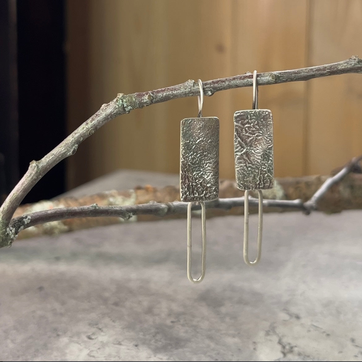 Reticulated sterling silver rectangle dangle earring with fixed earwire.  A sterline silver paperclip chain links hangs off the bottom of the earring body.