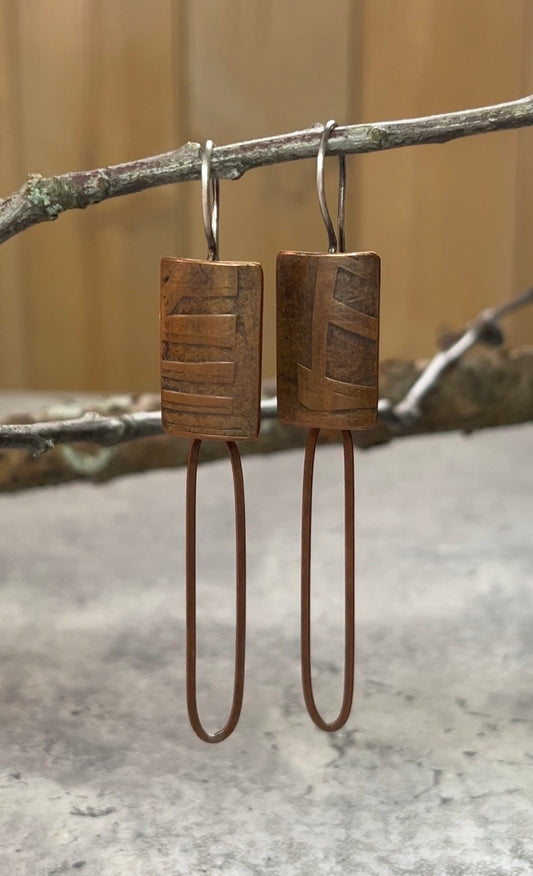 Roller printed copper, with rich patina, rectangle dangle earring with fixed earwire.  A copper silver paperclip chain links hangs off the bottom of the earring body.